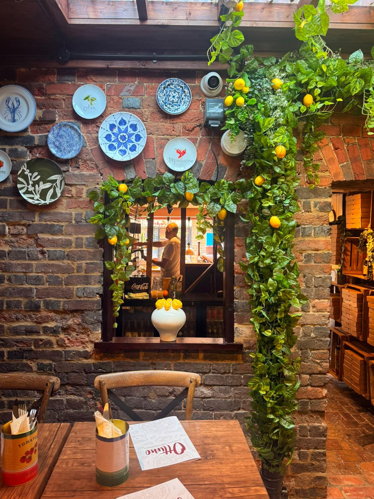 Hand-painted blue and white Italian plates on the exposed brick wall